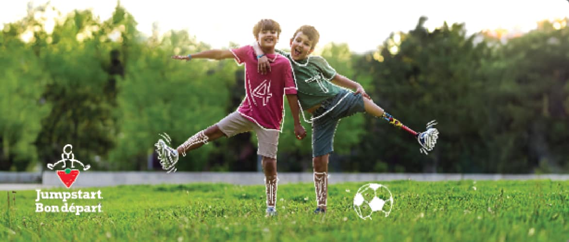Two boys play soccer in a field.