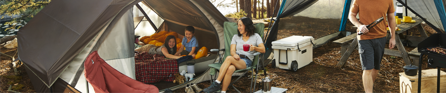 Une famille sur un terrain de camping dans les bois.