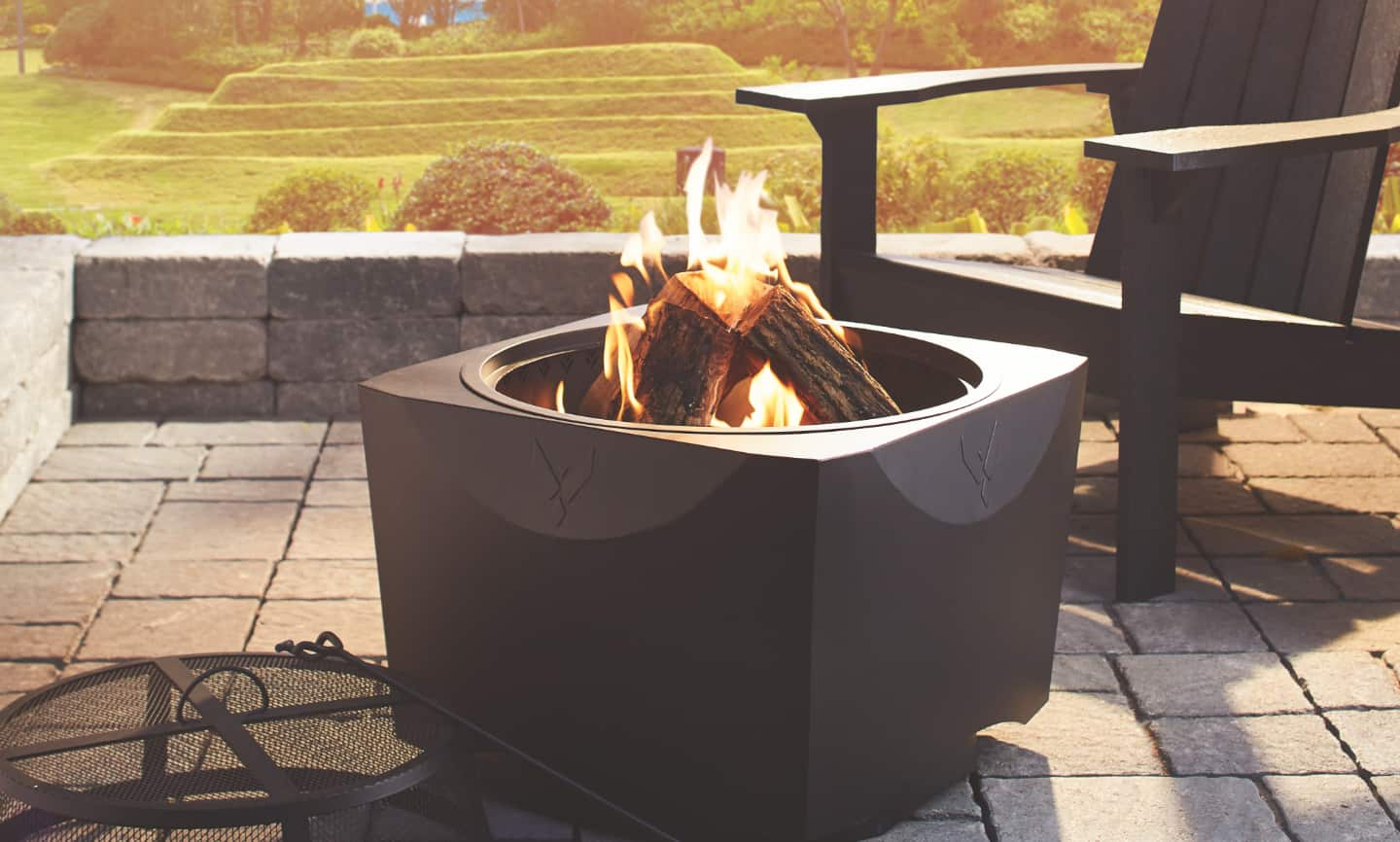 A blazing fire pit on a backyard patio.