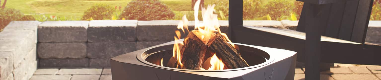 A blazing fire pit on a backyard patio.